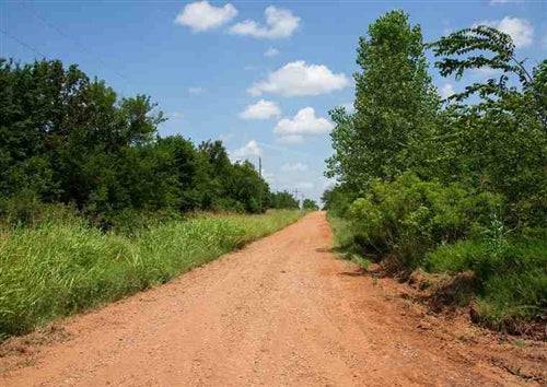 Aerial view of Oklahoma Deep Fork Ranch Lot 6 in Okfuskee County, showing land with nearby electrical infrastructure.