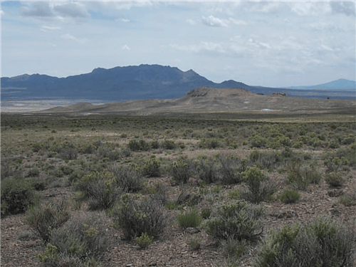 Scenic view of Nevada Elko County Mountain Meadow Ranches parcel 424, showing open land and mountain background.